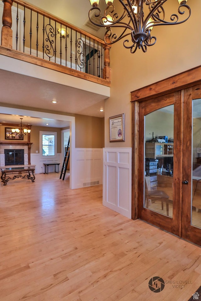 692 E 5020 N, Enoch, UT 84721 - entryway with a chandelier, wood finished floors, a high ceiling, a wainscoted wall, and a decorative wall