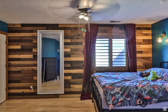 692 E 5020 N, Enoch, UT 84721 - bedroom featuring wooden walls, a textured ceiling, and wood finished floors
