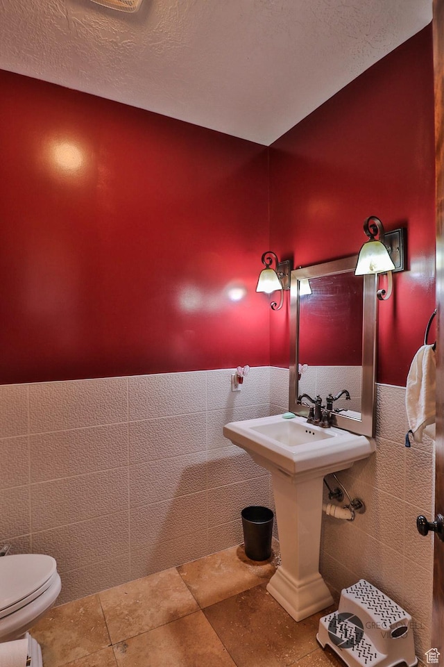 692 E 5020 N, Enoch, UT 84721 - bathroom with toilet, tile walls, a textured ceiling, and a sink