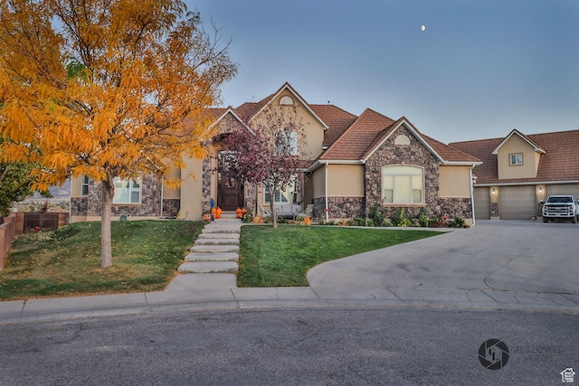 692 E 5020 N, Enoch, UT 84721 - view of front of property with stone siding, concrete driveway, a front lawn, and stucco siding