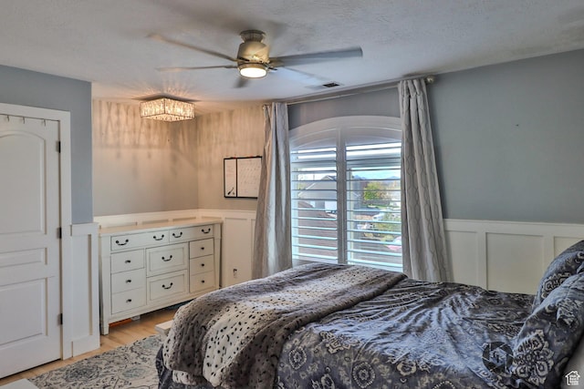 692 E 5020 N, Enoch, UT 84721 - bedroom with a decorative wall, a wainscoted wall, light wood-type flooring, and ceiling fan