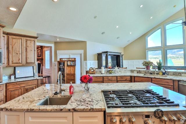 692 E 5020 N, Enoch, UT 84721 - kitchen with a sink, gas cooktop, light stone counters, high vaulted ceiling, and plenty of natural light