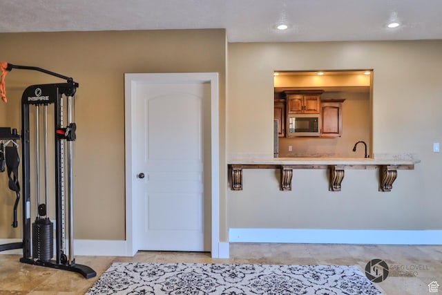 692 E 5020 N, Enoch, UT 84721 - kitchen featuring black microwave, brown cabinetry, baseboards, light countertops, and a breakfast bar area