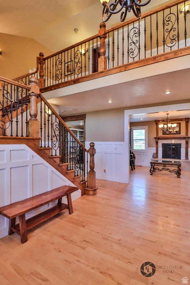 692 E 5020 N, Enoch, UT 84721 - staircase with a chandelier, wood finished floors, a decorative wall, high vaulted ceiling, and wainscoting