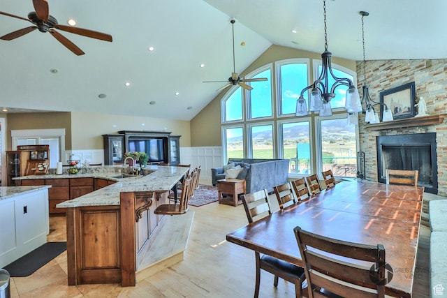 692 E 5020 N, Enoch, UT 84721 - kitchen featuring ceiling fan, high vaulted ceiling, a sink, open floor plan, and brown cabinets