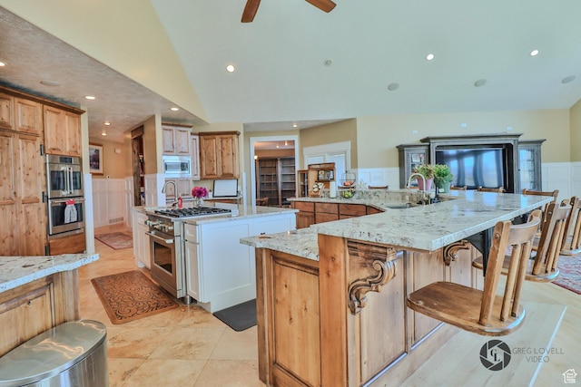 692 E 5020 N, Enoch, UT 84721 - kitchen featuring a sink, stainless steel appliances, a large island with sink, vaulted ceiling, and light stone counters