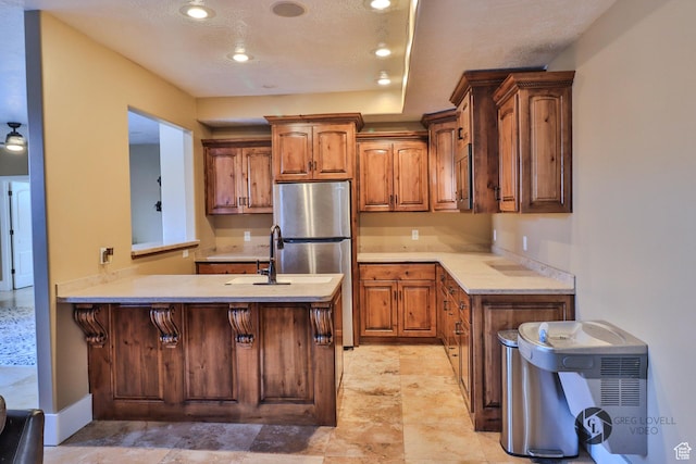 692 E 5020 N, Enoch, UT 84721 - kitchen with freestanding refrigerator, light countertops, a peninsula, brown cabinets, and recessed lighting