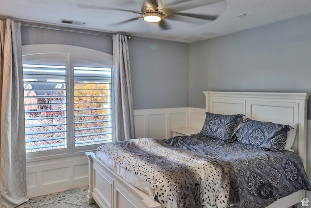 692 E 5020 N, Enoch, UT 84721 - bedroom featuring a decorative wall, multiple windows, a wainscoted wall, and ceiling fan