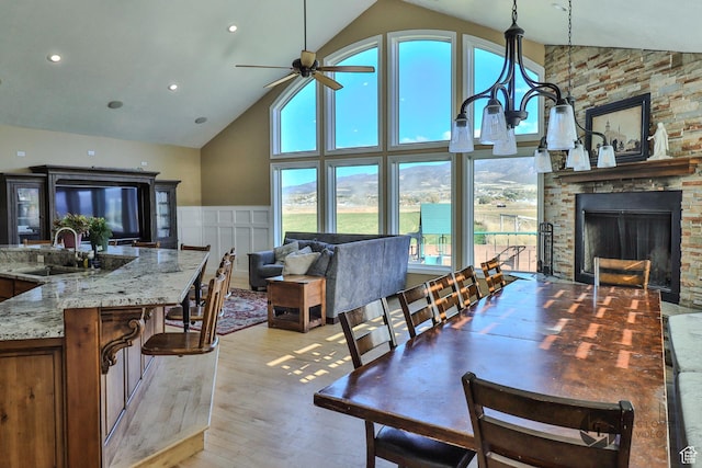 692 E 5020 N, Enoch, UT 84721 - dining area with high vaulted ceiling, light wood finished floors, a ceiling fan, a stone fireplace, and recessed lighting