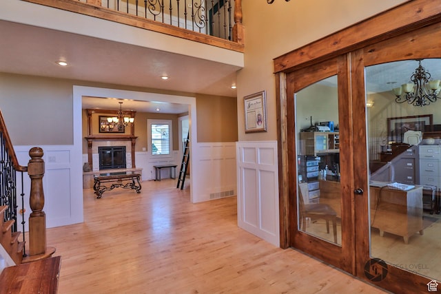 692 E 5020 N, Enoch, UT 84721 - foyer entrance with a chandelier, a decorative wall, light wood-style floors, stairs, and wainscoting