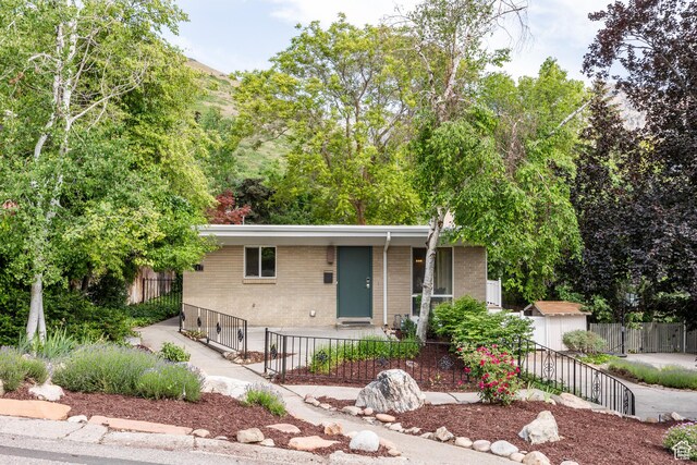 3427 S Fleetwood Dr, Salt Lake City, UT 84109 - view of front of home featuring brick siding and a fenced front yard