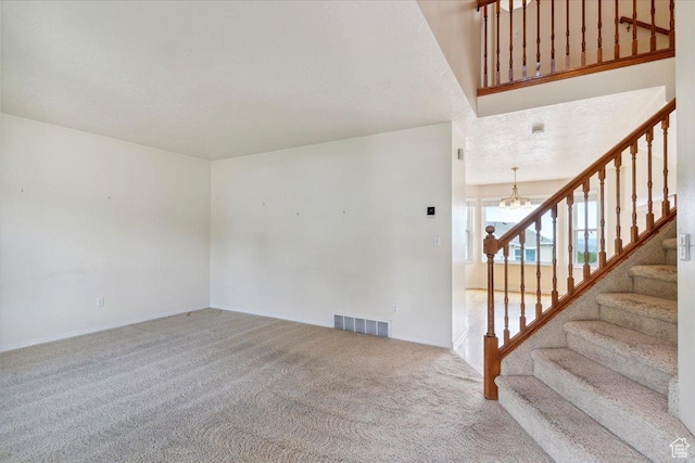 497 E 3525 N, North Ogden, UT 84414 - unfurnished living room with carpet floors, stairs, a chandelier, and baseboards