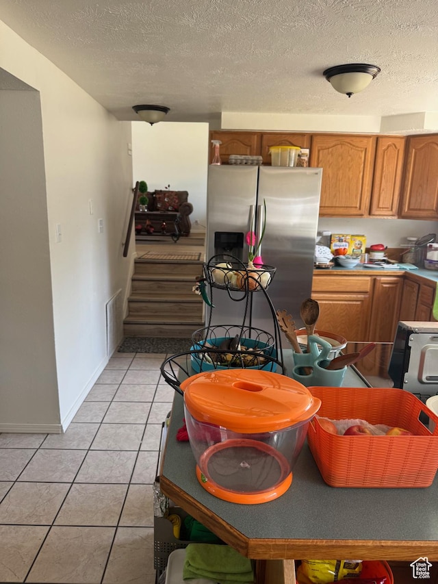 1102 W 860 N, Provo, UT 84604 - kitchen featuring stainless steel refrigerator with ice dispenser, light tile patterned floors, brown cabinetry, and a textured ceiling