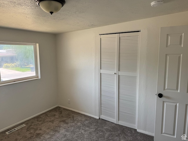 1102 W 860 N, Provo, UT 84604 - unfurnished bedroom with a closet, a textured ceiling, and dark colored carpet