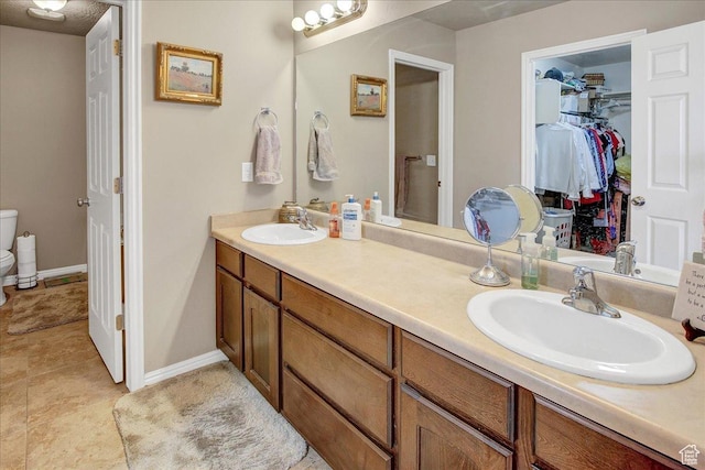 2118 W Foxwood St, West Haven, UT 84401 - full bathroom featuring toilet, double vanity, a spacious closet, and baseboards