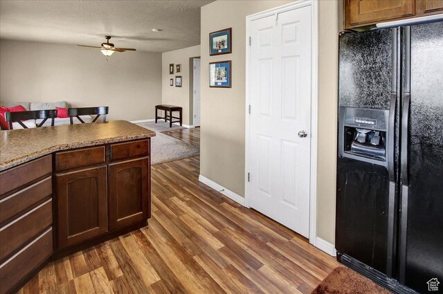 2118 W Foxwood St, West Haven, UT 84401 - kitchen with black fridge, dark wood finished floors, a ceiling fan, baseboards, and a textured ceiling