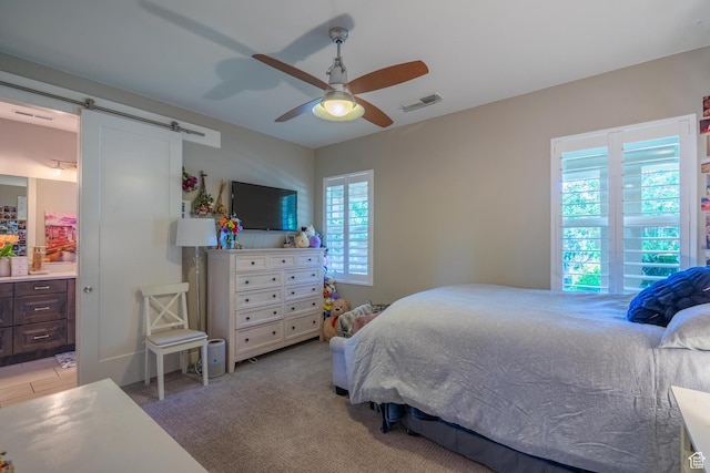 2573 S 3160 E, St George, UT 84790 - bedroom with a barn door, ceiling fan, and connected bathroom