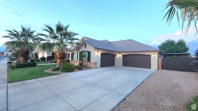 2573 S 3160 E, St George, UT 84790 - view of front of home featuring a garage, concrete driveway, stucco siding, and a tile roof