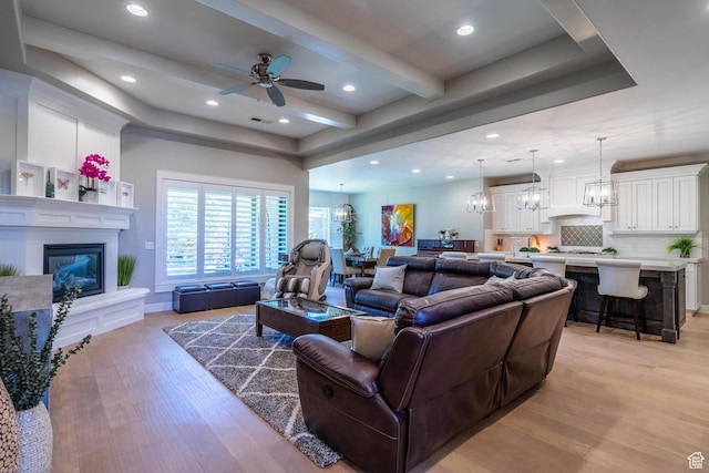 2573 S 3160 E, St George, UT 84790 - living area featuring a glass covered fireplace, a chandelier, light wood finished floors, a ceiling fan, and recessed lighting