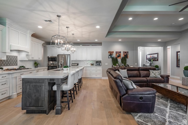 2573 S 3160 E, St George, UT 84790 - kitchen with open floor plan, stainless steel appliances, a kitchen breakfast bar, light countertops, and decorative backsplash