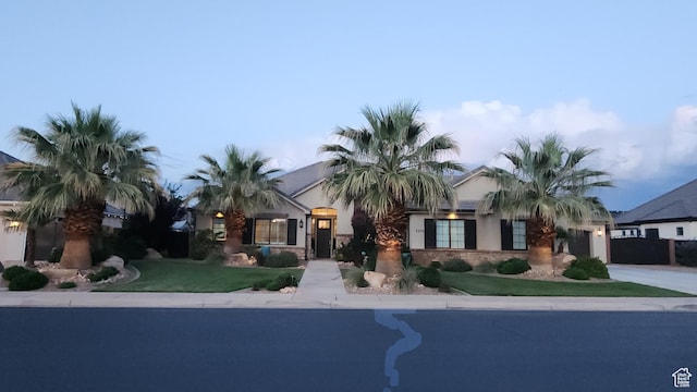 2573 S 3160 E, St George, UT 84790 - view of front of home with concrete driveway, a garage, a front lawn, and stucco siding