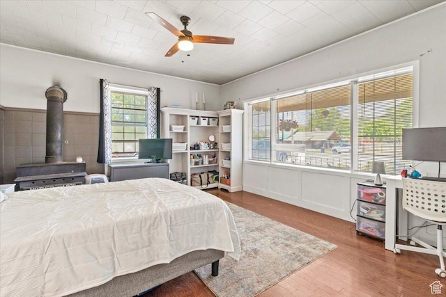 125 W 300 S, Ephraim, UT 84627 - bedroom with a wood stove, wood finished floors, ceiling fan, and a wainscoted wall