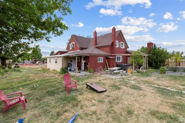 125 W 300 S, Ephraim, UT 84627 - rear view of house featuring a hot tub, a patio, brick siding, and a chimney