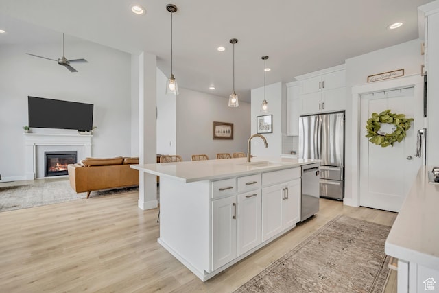 207 S Summer Breeze Ln, Layton, UT 84041 - kitchen with a sink, stainless steel appliances, light countertops, light wood-style flooring, and a ceiling fan