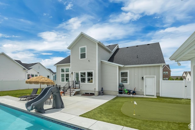 207 S Summer Breeze Ln, Layton, UT 84041 - rear view of house with a putting green, a patio area, board and batten siding, and a fenced backyard