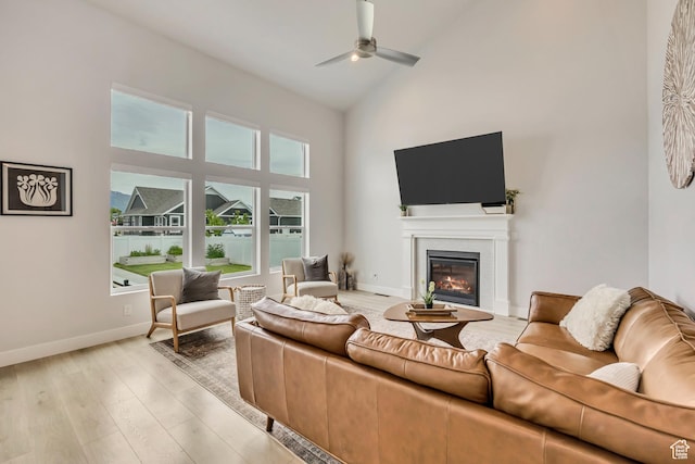 207 S Summer Breeze Ln, Layton, UT 84041 - living room with high vaulted ceiling, ceiling fan, a glass covered fireplace, light wood-type flooring, and baseboards