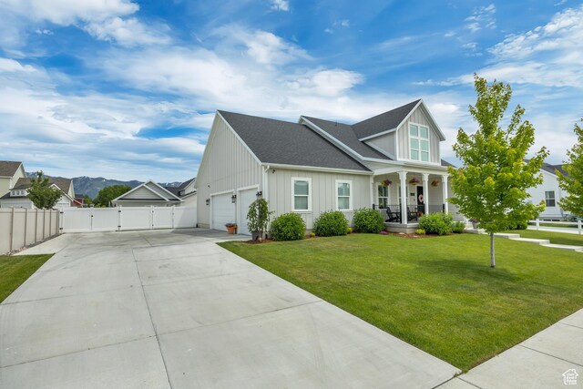 207 S Summer Breeze Ln, Layton, UT 84041 - view of front of home featuring a gate, board and batten siding, covered porch, driveway, and a garage