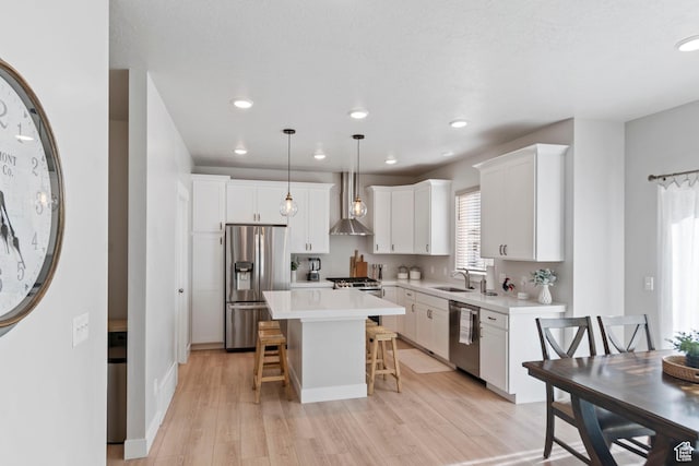 4827 N Sage Dr, Eagle Mountain, UT 84005 - kitchen with stainless steel appliances, a sink, a breakfast bar area, light wood-style flooring, and light countertops