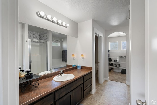 78 W Wildflower Dr, Saratoga Springs, UT 84045 - full bath featuring a shower stall, vanity, a textured ceiling, toilet, and tile patterned flooring