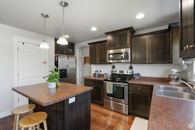 78 W Wildflower Dr, Saratoga Springs, UT 84045 - kitchen featuring appliances with stainless steel finishes, a sink, a center island, dark brown cabinetry, and arched walkways