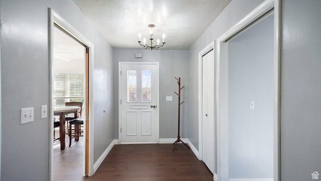 143 E 100 N, Gunnison, UT 84634 - foyer with a chandelier, dark wood-style flooring, a textured ceiling, and baseboards
