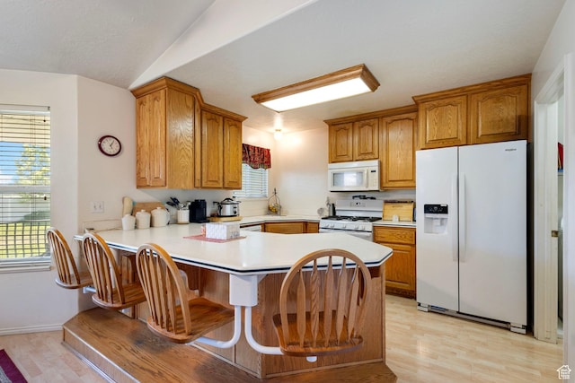 1202 N 2155 W, Clinton, UT 84015 - kitchen with white appliances, light wood-style floors, a peninsula, light countertops, and brown cabinetry