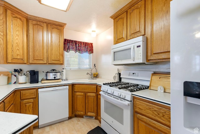 1202 N 2155 W, Clinton, UT 84015 - kitchen with white appliances, a sink, brown cabinetry, and light countertops