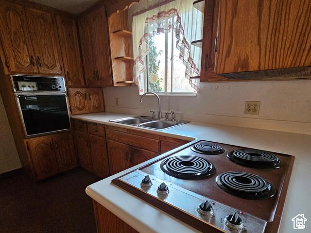 385 E 300 N, Spanish Fork, UT 84660 - kitchen featuring oven, stove, light countertops, a sink, and brown cabinetry