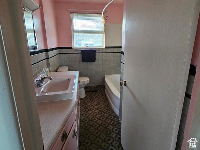 385 E 300 N, Spanish Fork, UT 84660 - bathroom with toilet, vanity, wainscoting, tile walls, and tub / shower combination