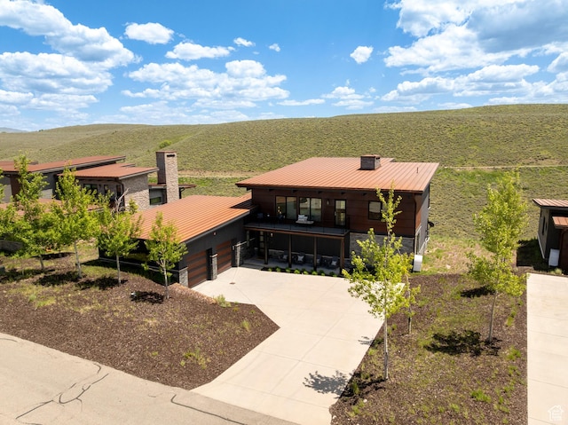 6650 Golden Bear Loop, Park City, UT 84098 - view of front facade featuring a chimney, metal roof, a standing seam roof, and concrete driveway