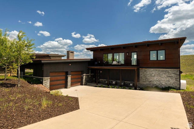 6650 Golden Bear Loop, Park City, UT 84098 - contemporary home with stone siding, a balcony, driveway, and a chimney