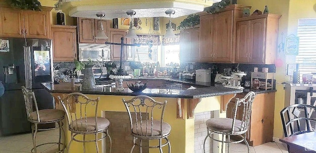 1559 S 2950 W, Vernal, UT 84078 - kitchen with stainless steel microwave, black fridge, a breakfast bar area, and backsplash