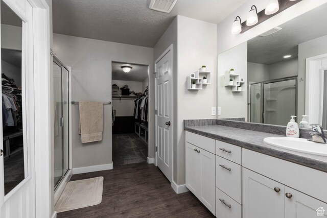 7709 N Seabiscuit Rd, Eagle Mountain, UT 84005 - full bath with a walk in closet, vanity, a shower stall, and a textured ceiling