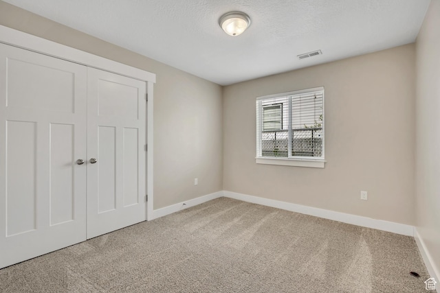 133 E Commonwealth Ave S, South Salt Lake, UT 84115 - unfurnished bedroom featuring baseboards, carpet floors, a closet, and a textured ceiling
