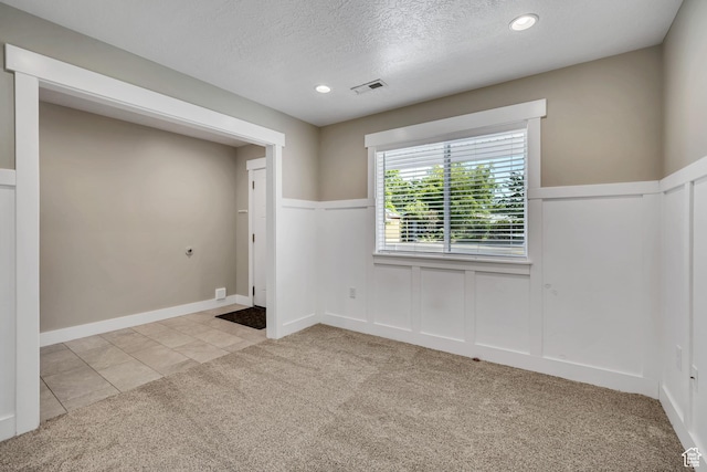 133 E Commonwealth Ave S, South Salt Lake, UT 84115 - carpeted spare room featuring wainscoting, a textured ceiling, recessed lighting, a decorative wall, and tile patterned flooring