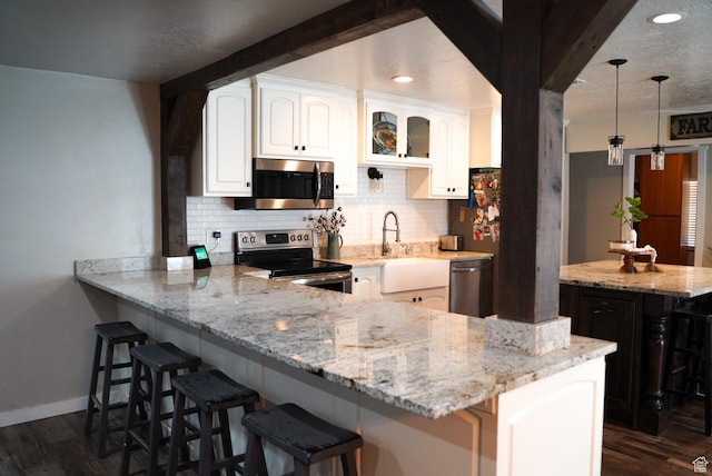 115 W 200 S, Wales, UT 84667 - kitchen featuring appliances with stainless steel finishes, tasteful backsplash, light stone counters, a breakfast bar area, and a sink