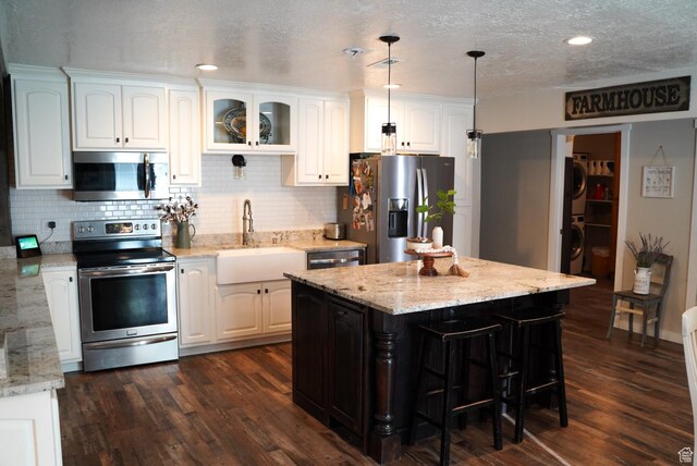 115 W 200 S, Wales, UT 84667 - kitchen with stainless steel appliances, a sink, white cabinets, backsplash, and a textured ceiling