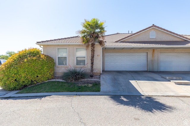 2056 E Middleton Clb, St George, UT 84770 - view of front of home featuring driveway, a garage, a tiled roof, and stucco siding