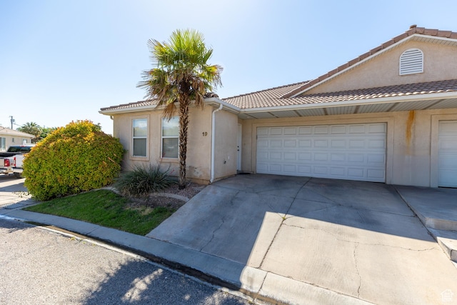 2056 E Middleton Clb, St George, UT 84770 - view of front of property with driveway, stucco siding, a garage, and a tile roof