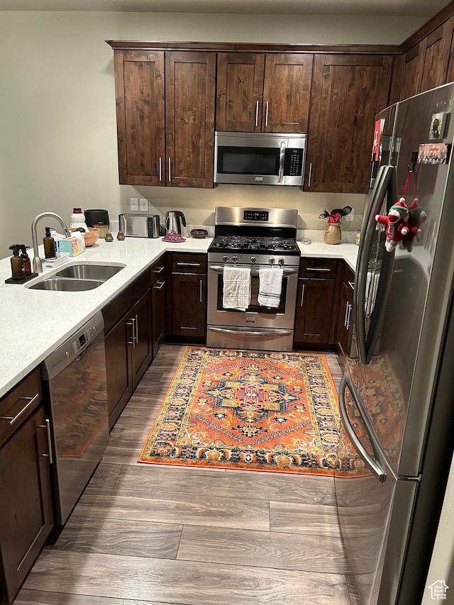 9681 S Zakro Ln, South Jordan, UT 84095 - kitchen featuring stainless steel appliances, a sink, wood finished floors, and dark brown cabinets